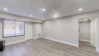 Located at 155 E Godfrey Ave in Philadelphia's 19120 neighborhood, this thoughtfully updated one-bedroom, one-bathroom unit offers a clean, modern aesthetic across a well-organized single-floor layout. Light-toned luxury vinyl plank flooring flows consistently throughout every room, complementing the neutral gray walls and crisp white trim for a cohesive, contemporary feel.

The open-concept living and kitchen area serves as the heart of the unit. The kitchen is equipped with stainless steel appliances — including a gas range with over-the-range microwave, dishwasher, and refrigerator — paired with sleek gray shaker-style cabinetry and white countertops. Recessed lighting illuminates the space efficiently throughout.

The spacious bedroom features a window with natural light, recessed ceiling lights, and direct access to a dedicated closet with built-in shelving — offering practical storage solutions. The hallway connects the living spaces to the private areas of the unit seamlessly.

The bathroom is a standout feature, showcasing a full soaking tub and shower combination adorned with striking horizontally-banded blue and gray tile, brushed nickel fixtures, and clean white walls that give it a spa-like quality.

Overall, the unit presents a move-in-ready, well-appointed space with modern finishes throughout.