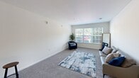 Located at 4825 Wallburg Landing St in Winston-Salem, NC, this single-story residence offers a well-designed, functional layout across a comfortable footprint. The living room is generously proportioned, featuring plush carpeting, neutral white walls, and a large window that fills the space with natural light and provides views of the surrounding greenery. The room easily accommodates a seating arrangement and area rug, creating a welcoming atmosphere. The kitchen is well-equipped, showcasing warm honey-toned wood cabinetry, dark granite countertops, tile flooring, and black appliances including a range, over-the-range microwave, and dishwasher — offering ample storage and workspace. The bedrooms are carpeted and bathed in natural light from well-placed windows, with ceiling fans providing comfort. One bedroom features a closet with built-in wire shelving, while another connects to an ensuite or adjoining bathroom. The bathroom includes a shower-tub combination with tile-style flooring and clean, neutral finishes. A dedicated laundry room with wire shelving, washer/dryer hookups, and light wood-look flooring adds practical convenience. Throughout, the space maintains a consistent, clean aesthetic with white walls, neutral carpeting, and thoughtful details.