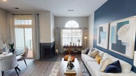 Located at 7838 Island Club Dr in Indianapolis, Indiana, this single-floor residence offers a thoughtfully designed layout with modern finishes and a cohesive contemporary aesthetic throughout. The living room serves as the focal point of the home, anchored by a striking deep-blue accent wall adorned with framed abstract artwork. A corner fireplace adds warmth and character, while a distinctive arched window fills the space with natural light. Wood-look flooring and high ceilings enhance the open, airy feel, and sliding glass doors lead to a private outdoor area. Adjacent to the living room, a cozy dining nook features large windows and direct access to the exterior, creating a bright and inviting atmosphere for everyday dining. The kitchen is well-appointed with granite countertops, two-tone cabinetry in white and gray, stainless steel appliances, a breakfast bar peninsula, and a skylight that brings in additional natural light. The bedrooms are carpeted and comfortably sized, each with ample natural light from window treatments. The primary bedroom features a soothing blue-gray accent wall, while the ensuite bathroom includes a granite vanity, wood-look flooring, a walk-in closet, and additional built-in shelving for generous storage. The overall design blends modern style with functional living throughout.