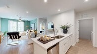 Located in Virginia Beach, VA, this well-appointed 2-bedroom, 2-bathroom home offers a thoughtfully designed single-floor layout with modern finishes throughout. The open-concept living and dining area is anchored by a soft sage green accent wall, light wood-style flooring, and generous natural light streaming through large windows dressed with sheer curtains. A woven pendant light adds a coastal warmth to the space.

The kitchen is both functional and stylish, featuring crisp white shaker cabinetry, white quartz countertops, subway tile backsplash, stainless steel appliances, and a peninsula with a stainless sink — flowing seamlessly into the dining and living areas.

The primary bedroom offers a comfortable, carpeted retreat with deep green accent walls, large windows, and ample closet space. The second bedroom is equally well-sized with neutral tones and natural light. Both bathrooms are finished with light wood-style flooring, white vanities with quartz countertops, subway tile surrounds, and glass-enclosed showers, exuding a clean, contemporary aesthetic.

Additional highlights include two closets for storage, and a dedicated in-unit laundry room with a full-size washer and dryer. This home combines modern design with practical living in a cohesive, move-in-ready package.