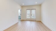 Located at 3311 Hood Ave in Chamblee, GA, this well-appointed one-bedroom, one-bathroom residence offers a thoughtfully designed single-floor layout. The open-concept living, dining, and kitchen area serves as the heart of the home, bathed in natural light from large windows and French doors that open to a private balcony with outdoor views. Light hardwood-style flooring flows throughout the main living spaces, complementing the bright, neutral color palette.

The kitchen is a standout feature, equipped with gray shaker-style cabinetry accented by matte black hardware, gleaming quartz countertops, a stainless steel undermount sink, and a full suite of stainless steel appliances including a gas range, microwave, dishwasher, and refrigerator. Recessed lighting throughout adds a clean, modern touch.

The bedroom is carpeted for comfort, features a ceiling fan, ample natural light from large windows, and is supported by three closets offering generous storage. The bathroom is finished with a gray vanity, quartz countertop, an illuminated LED mirror, and a subway-tiled walk-in shower. A dedicated laundry area completes this efficient and modern home.
