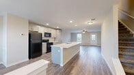 Located at 100 Union Knoll Dr in Middletown, Pennsylvania, this three-floor home offers a well-planned layout across three distinct levels. The main living floor features an open-concept kitchen and living room, where gray shaker-style cabinetry, a large center island with a white countertop and integrated sink, and black appliances create a functional and modern space. Recessed lighting illuminates the area, which flows seamlessly into the living room highlighted by wood-look luxury vinyl plank flooring and a ceiling fan. A welcoming entryway with a windowed front door adds natural light to this level. The upper floor hosts three bedrooms, including a generously proportioned primary suite with plush carpet, ceiling fan, and dual-door access to a closet. Additional bedrooms feature carpet or wood-look flooring, ceiling fans, and windows that bring in natural light. Three full bathrooms are finished with wood-look flooring, white vanities with ample cabinetry, and tub/shower combinations with clean white tile surrounds. The lower level presents an expansive unfinished utility and storage area with concrete flooring, drywall, a Trane HVAC system, and a separate exterior door — offering significant potential for future customization.