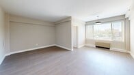 Located at 1500 Arlington Blvd in Arlington, VA, this one-bedroom, one-bathroom residence offers a thoughtfully arranged single-floor layout. The spacious bedroom features warm wood-style flooring, neutral taupe walls, clean white baseboards, and a built-in shelving ledge, creating a calm and versatile living space.

The open living area extends naturally from the bedroom, bathed in natural light through large windows fitted with horizontal blinds. A pendant light fixture adds a modern touch, while the wood-style flooring flows consistently throughout, lending cohesion to the space.

The kitchen is efficiently designed and features stainless steel appliances, including a gas range and over-the-range microwave, paired with white cabinetry and light countertops. A decorative geometric tile backsplash adds visual interest, while a bright window provides natural light and ventilation via an overhead exhaust fan.

The bathroom showcases classic white subway tile surrounding a full soaking tub and shower combination, accented by a bold black tile border along the top — a timeless design detail. A pedestal-style sink and mirrored medicine cabinet complete the clean, functional space.

A dedicated closet provides convenient storage. Overall, the residence presents a bright, move-in-ready environment with consistent modern finishes throughout.