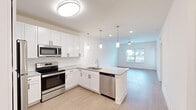 This well-appointed one-bedroom, one-bathroom unit in Athens, Alabama offers a thoughtfully designed open-concept layout that maximizes functionality and comfort. The kitchen is a standout feature, showcasing crisp white shaker cabinetry, granite countertops, a classic subway tile backsplash, and a full suite of stainless steel appliances including a refrigerator, range, microwave, and dishwasher. A peninsula with pendant lighting flows seamlessly into the living area, creating an ideal space for both cooking and entertaining. Light wood-style flooring runs throughout the main living areas, lending a clean, contemporary feel, while a ceiling fan adds comfort to the living space. Natural light filters in through windows dressed with blinds, offering views of the surrounding community. The bedroom features plush carpeting, a ceiling fan, and a window that brings in additional natural light. A dedicated closet provides practical storage. The bathroom is finished with a white shaker vanity topped with granite, white subway tile surrounding the tub and shower combination, and light wood-style flooring that ties the space together. A private exterior door offers convenient access, rounding out this efficiently designed and attractively finished residence.