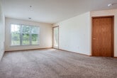 Located at 929 Harrington Dr in Madison, WI, this two-bedroom, one-bathroom single-floor home offers a well-organized and functional layout. The open-concept kitchen and living room form the heart of the space, where warm honey-toned cabinetry, stainless steel appliances — including a refrigerator, range, and dishwasher — and a breakfast bar peninsula create a practical yet inviting atmosphere. Wood-look flooring in the kitchen transitions seamlessly to plush carpeting throughout the living and bedroom areas. A ceiling fan in the living room adds comfort and airflow. Both bedrooms are carpeted and feature natural light from windows with views of surrounding greenery; the primary bedroom includes a ceiling fan, while the second bedroom offers direct patio access via a glass-panel door. The full bathroom is appointed with a wood-vanity, large mirror, tub/shower combination, and wood-look flooring. A dedicated laundry area is conveniently accessible from the kitchen. The home also boasts an impressive number of closets for generous storage throughout. A covered patio extends the living space outdoors, completing this comfortable and practical Madison residence.