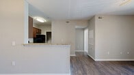 Located in Fort Worth, TX, this one-bedroom, one-bathroom residence offers a thoughtfully designed single-floor layout that makes efficient use of its space. Dark hardwood-style flooring runs throughout the main living areas, lending a warm, cohesive feel to the living room, dining area, and kitchen.

The living room is bright and airy, highlighted by a ceiling fan and a sliding glass door that opens to a private balcony with views of the surrounding community. Adjacent to the living room, the dedicated dining area features a pendant light fixture that anchors the space.

The kitchen is well-appointed with rich dark wood cabinetry, granite-style countertops, and black appliances including a range, microwave, and dishwasher. Ample counter and cabinet space make this an efficient and functional cooking area.

The bedroom is carpeted for comfort, features a ceiling fan, and includes a large window that brings in natural light and outdoor views. A walk-in closet provides generous storage. The full bathroom is finished with tile-surround tub and shower, a granite-topped vanity with dark wood cabinetry, and wood-style flooring.

A dedicated laundry room with full-size washer and dryer hookups adds everyday convenience, completing this practical and comfortable residence.