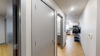 Located on the 7th floor at 615 S Wright St in Champaign, Illinois, this well-appointed one-bedroom, one-bathroom unit offers a functional and modern layout across a single floor. Light-toned hardwood-style flooring runs throughout, giving the space a clean, cohesive aesthetic.

The kitchen serves as a central highlight, featuring white cabinetry extending to the ceiling for ample storage, granite-look countertops, a mosaic tile backsplash, and a full suite of stainless steel appliances including a refrigerator, electric range, built-in microwave, and dishwasher. A dining table with seating for four sits comfortably in the kitchen area, making it ideal for everyday meals or group gatherings.

The bedroom is a comfortably sized private retreat with a window fitted with horizontal blinds that allow for natural light control. It includes space for a bed and dresser. An adjacent dedicated office area provides a quiet workspace, complete with a window overlooking the exterior — a practical feature for study or remote work.

The bathroom is clean and straightforward, featuring a full tub-shower combination with a glass enclosure, chrome fixtures, and hardwood-style flooring that continues from the rest of the unit.

A hallway connects the rooms efficiently, contributing to the unit's practical and well-organized flow throughout.