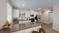 Located at 71 Palomar Avenue in San Luis Obispo, California, this well-designed single-story home offers four bedrooms and two full bathrooms across a thoughtfully arranged floor plan. The open-concept kitchen and dining area serves as the heart of the home, featuring crisp white shaker cabinets, classic subway tile backsplash, dark quartz countertops, stainless steel appliances including a dishwasher, range, microwave, and refrigerator, and a breakfast bar peninsula ideal for casual dining. The living room is bright and welcoming, with light wood-style flooring, multiple windows with blinds that invite natural light, and a ceiling fan overhead. Each bedroom offers a comfortable, functional layout with carpeted flooring, and some rooms benefit from additional natural light through well-placed windows. Both bathrooms are finished consistently with white cabinetry, dark quartz countertops, dual undermount sinks, large mirrors, and wood-style flooring, lending a clean, modern aesthetic throughout. Additional spaces include a dedicated laundry room, a utility room, a hallway, and a closet, enhancing everyday practicality. The home's contemporary design, cohesive finishes, and efficient layout make it a functional and comfortable residence in the heart of San Luis Obispo.
