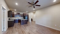 This single-story home in Conway, Arkansas offers a well-designed, functional layout with a consistent neutral color palette and modern finishes throughout. The open-concept living and kitchen area serves as the heart of the home, where rich dark-stained cabinetry reaches toward the ceiling, providing ample storage. Light granite countertops offer a striking contrast, and a center island extends the prep and dining space. Black appliances, including a refrigerator, range, microwave, and dishwasher, complete the kitchen. Wood-look flooring runs through the main living areas, adding warmth and durability.

The living area is spacious and bright, with a ceiling fan overhead and a window that allows natural light to filter in. Bedrooms feature plush carpeting, ceiling fans, and windows with blinds. One bedroom includes a walk-in closet outfitted with dual hanging rods and upper shelving. A dedicated laundry area accommodates a stacked washer and dryer unit. The bathroom includes a full-size soaking tub and shower combination with clean white surrounds and brushed nickel fixtures. The overall ambiance of the home is clean, neutral, and move-in ready.
