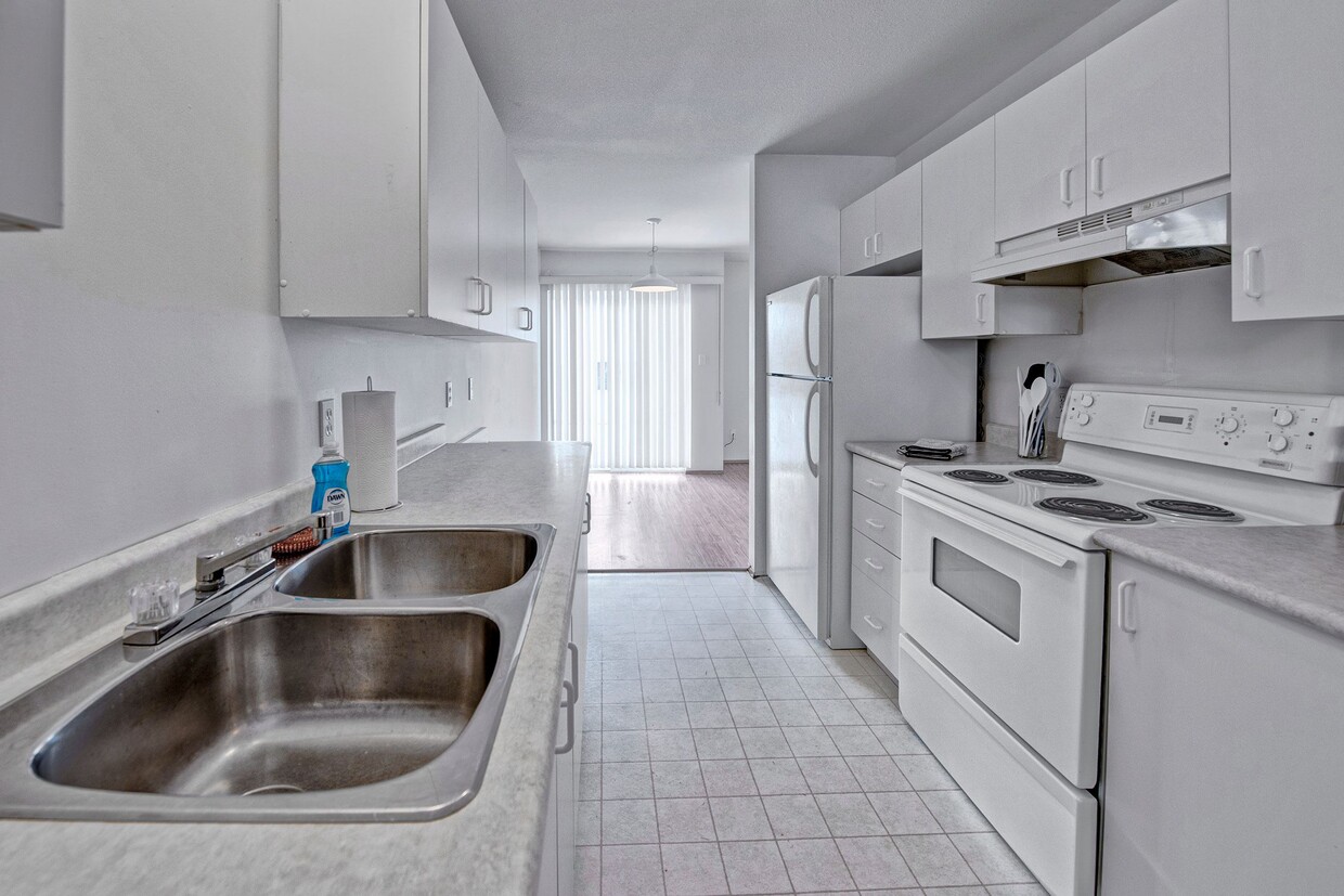 A kitchen with white appliances and white cabinetry - Willow View