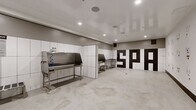 Located at 1912 S Jacaranda Street in Anaheim, CA 92805, Paw Spaw is a purpose-built, single-floor pet grooming facility spanning 400 square feet. The space is thoughtfully divided into two functional zones. The first is a open reception or play area featuring polished concrete floors, recessed lighting, and white walls adorned with a charming array of hand-drawn dog-face illustrations in black ink, creating a welcoming and pet-friendly atmosphere. A bold black-and-white geometric entry door adds a striking design accent to this area. The second zone serves as the professional grooming area, equipped with multiple stainless steel grooming tubs featuring integrated fixtures and hose attachments, stainless steel utility tables, and floor drains for efficient cleanup. The walls in this section are clad in large-format white tiles, ensuring a hygienic and easy-to-clean surface. Recessed ceiling lights illuminate both areas evenly, while the high-gloss ceiling finish enhances brightness throughout. The durable polished concrete flooring flows seamlessly across the entire space, providing a practical and modern aesthetic suited to the demands of a professional pet grooming operation.