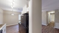 This single-floor residence in South Carolina offers a thoughtfully designed layout with consistent finishes throughout. Rich, dark hardwood-style flooring flows seamlessly across the living areas, bedrooms, and kitchen, creating a cohesive and inviting aesthetic.

The kitchen is a standout feature, showcasing crisp white shaker-style cabinetry with brushed nickel hardware, granite-look countertops, black appliances including a range and refrigerator, and a double stainless steel sink. Track lighting illuminates the galley-style workspace, which also connects to additional storage or utility space.

The open living and dining area is generously proportioned, filled with natural light from large windows fitted with blinds, and equipped with a ceiling fan with light fixture. The space flows comfortably for both everyday living and entertaining.

Multiple bedrooms offer well-sized, versatile spaces, each featuring the same hardwood-style flooring, neutral warm-toned walls, ceiling fans, and windows that allow ample natural light. The bathroom is clean and modern, featuring a tub/shower combination surrounded by classic white subway tile with dark grout detailing, offering a timeless and easy-to-maintain finish.

Throughout the home, neutral paint tones, white trim, and consistent flooring contribute to a bright, unified feel that is both functional and move-in ready.