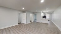 This thoughtfully renovated single-floor space presents a bright, open layout finished in a consistent neutral palette of soft grays and crisp white trim. Light wood-look luxury vinyl plank flooring runs seamlessly throughout the main living areas and bedrooms, creating a cohesive and contemporary feel underfoot. Recessed lighting illuminates the spacious open-plan living and dining area, which connects directly to the kitchen via a peninsula counter — ideal for both everyday living and entertaining.

The kitchen is a standout feature, outfitted with white shaker-style cabinetry with matte black hardware, quartz countertops, a herringbone tile backsplash, and a full suite of stainless steel appliances including a gas range, over-the-range microwave, dishwasher, and refrigerator. A window above the sink brings in natural light.

The bedroom offers generous proportions, a double closet with built-in rod, and its own recessed lighting. A dedicated entrance area provides additional storage and transition space. The bathroom is cleanly appointed with dark porcelain tile flooring, a white vanity with matte black fixtures, a wall-mounted mirror with overhead lighting, and a full soaking tub. Every detail reflects a clean, move-in-ready finish with modern sensibilities.