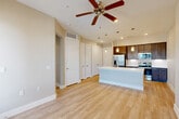 Located at 101 Crawford St in Houston, TX, this one-bedroom, one-bathroom residence offers a thoughtfully designed single-floor layout that maximizes every square foot. Light wood-style flooring flows throughout the main living areas, creating a cohesive and airy atmosphere. The open-concept kitchen and dining area is anchored by a white-topped island with a built-in sink, complemented by rich dark cabinetry, a herringbone tile backsplash, pendant lighting, and a full suite of stainless steel appliances including a refrigerator, range, and over-the-range microwave. The living area features a ceiling fan and direct access to a balcony with views of the Houston downtown skyline. The generously sized bedroom is carpeted, includes a ceiling fan, and offers abundant natural light through large windows that also frame city views. Five closets throughout the unit provide exceptional storage. The full bathroom features a long dark wood vanity with a white countertop, a soaking tub with classic white subway tile surround, a separate glass-enclosed shower, and light wood-style flooring. An in-unit laundry area adds everyday convenience. The warm, neutral palette throughout creates a clean, modern ambiance.