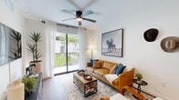 Located at 4181 Davie Road in Davie, FL, this well-appointed 2-bedroom, 2-bathroom residence offers a thoughtfully designed single-level layout. Warm wood-look flooring flows throughout, tying together a cohesive, modern aesthetic defined by crisp white walls and clean lines.

The open-concept kitchen is a standout feature, showcasing light gray cabinetry, a dark tile backsplash, stainless steel appliances, and a large waterfall-edge island with seating — ideal for both casual dining and entertaining. Pendant lighting adds a stylish focal point above the island.

The living room is bright and inviting, with a sliding glass door opening to a private balcony overlooking green outdoor space. A ceiling fan and sheer white curtains enhance the airy feel of the room.

The spacious primary bedroom features warm wood tones, ample natural light, and direct access to a well-appointed en-suite bathroom with a frameless glass walk-in shower and modern vanity. The second bedroom is generously sized with a dedicated walk-in closet and a bright window. The second bathroom offers a full soaking tub and shower combo with clean tile surround. A separate closet provides additional storage, completing this well-rounded and functional residence.