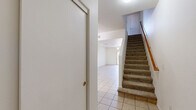 Located in Gilbert, AZ, this two-story home offers a well-organized layout across two floors. The main level features light tile flooring throughout and hosts the combined living, dining, and kitchen area. The kitchen is equipped with warm wood cabinetry, dark granite-style countertops, black appliances including a refrigerator, electric range, microwave, and dishwasher, along with a double sink and a window that brings in natural light. The open dining and living areas connect seamlessly, with a sliding glass door leading to a private patio with neighborhood views. A carpeted staircase with a wood handrail leads to the upper level. The three bedrooms are located upstairs, each featuring plush carpet flooring, ceiling fans with light fixtures, and windows fitted with vertical blinds. The primary bedroom offers a generous footprint with ample closet space. Two full bathrooms serve the home — one featuring wood-look flooring, a single vanity, toilet, and a tub/shower combo. Additional highlights include multiple closets throughout, a dedicated laundry area, and a clean, neutral color palette that provides a bright, move-in-ready atmosphere throughout the home.