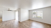 Located at 1349 W Horizon Ridge Pkwy in Henderson, NV, this 2-bedroom, 2-bathroom single-story residence offers a well-organized layout designed for comfortable everyday living. The open living room is bright and welcoming, featuring wood-style plank flooring, a textured ceiling, a ceiling fan, and a large window that fills the space with natural light and outdoor views of surrounding greenery. The galley-style kitchen is efficiently designed with light wood cabinetry, laminate countertops, a stainless steel sink, white appliances including a refrigerator, range, and microwave, and track lighting overhead — all complemented by matching wood-style flooring. The primary bedroom is a generous, well-proportioned room with carpet flooring, a window with outdoor views, and direct access to a dedicated closet. The second bedroom also features plush carpet and a window allowing in natural light. Both bathrooms are functionally appointed with a vanity, mirror, and a shower-tub combination with wood-style flooring. Additional storage is provided by two closets, including one walk-in closet with wire shelving. A connecting hallway ties the layout together seamlessly, providing easy access to all rooms throughout this clean, move-in-ready residence.