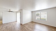 Located at 1349 W Horizon Ridge Pkwy in Henderson, NV, this 2-bedroom, 2-bathroom single-story residence offers a well-organized layout designed for comfortable everyday living. The open living room is bright and welcoming, featuring wood-style plank flooring, a textured ceiling, a ceiling fan, and a large window that fills the space with natural light and outdoor views of surrounding greenery. The galley-style kitchen is efficiently designed with light wood cabinetry, laminate countertops, a stainless steel sink, white appliances including a refrigerator, range, and microwave, and track lighting overhead — all complemented by matching wood-style flooring. The primary bedroom is a generous, well-proportioned room with carpet flooring, a window with outdoor views, and direct access to a dedicated closet. The second bedroom also features plush carpet and a window allowing in natural light. Both bathrooms are functionally appointed with a vanity, mirror, and a shower-tub combination with wood-style flooring. Additional storage is provided by two closets, including one walk-in closet with wire shelving. A connecting hallway ties the layout together seamlessly, providing easy access to all rooms throughout this clean, move-in-ready residence.