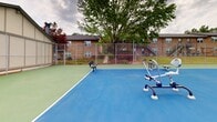 Located at 3908 Bearden Dr in Birmingham, Alabama, this outdoor recreational facility serves as a central amenity hub for its surrounding residential community. The space is anchored by a full-size tennis court surfaced in a classic blue and green hard court finish, complete with a regulation net and chain-link perimeter fencing. Courtside benches provide seating for players and spectators alike, while outdoor fitness stations installed directly on the court surface offer additional exercise options without requiring a separate facility.

Adjacent to the tennis court lies a swimming pool area, lined with lounge chairs and shaded by an umbrella, making it an inviting retreat during warm Alabama summers. The pool is enclosed within its own fenced boundary, ensuring safety and defined access.

The complex is framed by two-story brick residential buildings featuring exterior staircases, neutral trim, and dark shingled rooflines — a sturdy, traditional architectural aesthetic common to the region. Mature trees throughout the grounds provide natural shade and a pleasant, established landscape. The combination of sport, fitness, and leisure amenities within a single, well-defined outdoor space makes this facility a versatile and practical recreational destination for residents of the Bearden Drive community.