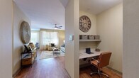 This thoughtfully designed 2-bedroom, 2-bathroom single-story residence offers a comfortable and functional layout with warm, neutral tones throughout. Rich hardwood-style flooring flows through the main living areas, complemented by ceiling fans that add both style and practicality.

The living room features a bold accent wall, a ceiling fan, and connects seamlessly to the hallway, which includes a convenient built-in desk nook — ideal for a home office setup. The dining area is bathed in natural light from a large window with views of greenery outside, creating a bright and inviting atmosphere.

The kitchen is well-equipped with warm wood cabinetry, granite countertops, stainless steel appliances, and track lighting overhead. A dedicated in-unit laundry room with a full-size washer and dryer adds everyday convenience.

The generously sized primary bedroom features plush carpeting, a ceiling fan, and ample closet space, including a large walk-in closet with wire shelving. The bathrooms are finished with wood-toned vanity cabinetry, light countertops, and classic white subway tile surrounding the tub-shower combinations. Two closets throughout the home provide abundant storage for all residents.