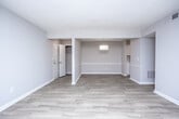 Located at Belmont Park Drive in Smyrna, Georgia, this single-story unit offers a clean, updated interior with a neutral color palette and consistent wood-style flooring throughout. The open living area is bright and welcoming, anchored by a sliding glass door fitted with vertical blinds that provides access to an outdoor space and allows natural light to fill the room. An adjacent dining area connects seamlessly to the living space, illuminated by a pendant light fixture that adds a warm ambiance.

The kitchen features white cabinetry, a subway tile backsplash, and a stainless steel electric range with a ventilation hood above, reflecting a contemporary and functional design. A hallway connects the private areas of the unit, leading to the bedrooms and bathroom. The bedrooms feature the same wood-style flooring, neutral gray walls, and textured ceilings. One bedroom includes a window with blinds for natural light and a closet with built-in shelving.

The bathroom is finished with wood-look tile flooring, a white vanity with under-cabinet storage, a framed mirror with bar lighting above, and a toilet, offering a tidy and practical layout. Throughout the unit, clean white baseboards and consistent finishes contribute to a cohesive, move-in-ready aesthetic.