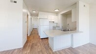 Located at 1692 S Riverside Dr in Salt Lake City, UT, this two-story, 3-bedroom, 2-bathroom home offers a practical and comfortable layout spread across two floors. The main level features an open-concept living, dining, and kitchen area anchored by a peninsula with light stone-look countertops, a double-basin sink, and crisp white cabinetry. Wood-look flooring runs throughout the main level, adding warmth and cohesion to the space. A pendant chandelier in the dining area and recessed lighting in the kitchen provide well-distributed illumination. The main floor also includes a dedicated laundry room with wire shelving and washer/dryer hookups, plus access to an attached garage. Upstairs, three bedrooms are carpeted and feature neutral walls and natural light from multiple windows with outdoor views of surrounding greenery. The primary bedroom provides a comfortable retreat with ample square footage. Six closets throughout the home ensure generous storage, complemented by two hallways that connect the spaces efficiently. Two full bathrooms — including one with a bathtub — complete the layout. With a clean, neutral palette throughout, this home offers a move-in-ready canvas well-suited for a variety of living arrangements.