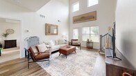 Located at 704 S Hemlock St in Gardner, Kansas, this two-story space offers a well-appointed layout across two floors, with the main level comprising the majority of the floor area. The living room is an immediate standout, featuring soaring vaulted ceilings with clerestory windows that flood the space with natural light, complemented by hardwood-style flooring and a warm, modern aesthetic. The kitchen is thoughtfully designed with gray shaker-style cabinetry, gleaming quartz countertops, stainless steel appliances, and a central island with bar seating — ideal for both daily use and entertaining. A dedicated dining area adjacent to the kitchen benefits from large windows overlooking the outdoors and is accented by a ceiling fan. Three full bathrooms are distributed throughout the space, each finished with tile flooring, vanities with quartz counters, and tub/shower combinations. The upper level hosts office spaces tucked under the roofline, featuring carpeted floors, ceiling fans, and ample workspace. Additional offices on the main level include a distinguished private office with a tray ceiling, large window, and plush carpet. A closet rounds out the functional layout of this versatile, multi-use space.