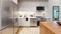 Located at 1100 McCallum Rd in Langford, BC, this thoughtfully designed one-bedroom, one-bathroom residence offers a clean, contemporary aesthetic throughout. The open-concept layout makes excellent use of space, with light hardwood flooring and crisp white walls creating a bright, airy atmosphere.

The kitchen is a standout feature, equipped with full stainless steel appliances including a French door refrigerator, gas range, built-in dishwasher, and over-the-range microwave. Sleek grey cabinetry extends to the ceiling, paired with white quartz countertops and a subway tile backsplash. A warm wood-topped island anchors the space, providing additional prep area and casual dining. The kitchen flows naturally into the living area, which benefits from large windows and a wall-mounted mini-split system for year-round comfort.

The bedroom is a serene retreat featuring tall ceilings, large windows with outdoor greenery views, and direct access to a dedicated closet. The bathroom is finished in a clean, modern palette with a wood-accented vanity, white tile flooring, and contemporary fixtures. A private balcony, in-suite laundry, and additional storage further enhance the functionality of this well-appointed home.