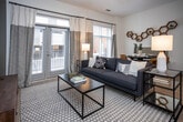 Located at 355 Walnut St in Chattanooga, TN, this single-floor residence offers a thoughtfully designed layout with modern finishes and a cohesive aesthetic throughout. Light wood-tone flooring runs through the main living areas, tying the space together with a warm, contemporary feel.

The kitchen is a standout feature, equipped with stainless steel appliances including a refrigerator, electric range, and built-in microwave. Gray shaker-style cabinetry provides ample storage, while granite countertops and a subway tile backsplash add refined detail. The kitchen flows seamlessly into the hallway, which connects all areas of the residence.

The living room is generously proportioned, anchored by a bold olive-green accent wall that adds depth and character. Light-filtering window treatments allow natural light to fill the room, complementing the light flooring and neutral tones.

The bedroom features a distinctive vertical-striped accent wall, plush carpeting, and warm lighting, creating a calm and restful environment. An adjacent bathroom offers a clean, white tile surround tub-shower combo, granite vanity, and gray cabinetry consistent with the home's overall palette. Additional storage is provided by a walk-in closet accessible from the entry hallway. The space presents a well-balanced blend of style and functionality.