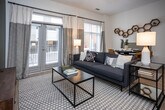 Located at 355 Walnut St in Chattanooga, TN, this single-floor residence offers a thoughtfully designed layout with modern finishes and a cohesive aesthetic throughout. Light wood-tone flooring runs through the main living areas, tying the space together with a warm, contemporary feel.

The kitchen is a standout feature, equipped with stainless steel appliances including a refrigerator, electric range, and built-in microwave. Gray shaker-style cabinetry provides ample storage, while granite countertops and a subway tile backsplash add refined detail. The kitchen flows seamlessly into the hallway, which connects all areas of the residence.

The living room is generously proportioned, anchored by a bold olive-green accent wall that adds depth and character. Light-filtering window treatments allow natural light to fill the room, complementing the light flooring and neutral tones.

The bedroom features a distinctive vertical-striped accent wall, plush carpeting, and warm lighting, creating a calm and restful environment. An adjacent bathroom offers a clean, white tile surround tub-shower combo, granite vanity, and gray cabinetry consistent with the home's overall palette. Additional storage is provided by a walk-in closet accessible from the entry hallway. The space presents a well-balanced blend of style and functionality.