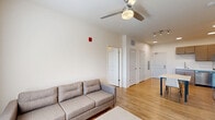 Located at 418 Harrison St in West Lafayette, Indiana, this thoughtfully designed 2-bedroom, 2-bathroom unit offers a clean, modern aesthetic across a single floor. The open-concept kitchen and living area serves as the heart of the unit, where light tan cabinetry, stainless steel appliances — including a refrigerator, electric range, built-in microwave, and dishwasher — and white countertops create a functional yet stylish kitchen space. Wood-style flooring flows throughout, adding warmth and continuity to every room. The living area is bright and welcoming, benefiting from natural light through window treatments, a ceiling fan, and a wall-mounted TV. Two bedrooms offer comfortable, private retreats, each with a ceiling fan, natural light, and closet storage — three closets in total are distributed throughout the unit. Both bathrooms feature wood-tone vanities and durable flooring; one includes a walk-in shower, while the other provides a more compact layout. A dedicated laundry area adds everyday convenience. The unit's neutral palette, recessed and track lighting, and consistent finishes give the space a cohesive, move-in-ready feel well-suited for residents seeking modern comfort in West Lafayette.