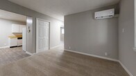 Located at 910 Brown Dr in Murfreesboro, Tennessee, this single-story, 2-bedroom, 1-bathroom home offers a practical and comfortable layout. The living room greets you at the entrance, featuring neutral gray walls, carpet flooring, and a front-facing window that brings in natural light. The kitchen is efficiently designed with white cabinetry, warm wood-tone countertops, a double sink, and a freestanding range, complemented by wood-look plank flooring. Both bedrooms are carpeted and finished in soft gray tones, each equipped with a wall-mounted mini-split HVAC unit for individual climate control. The primary bedroom includes a paneled closet with a hanging rod, offering practical storage. The second bedroom features a ceiling fan with light fixture, adding to the room's comfort. Each bedroom is served by natural light through windows with blinds. The full bathroom includes a tub-shower combination with tile surround, a vanity with storage, a toilet, wood-look flooring, and built-in open shelving for added convenience. Throughout the home, clean white trim and neutral paint tones create a cohesive, move-in ready atmosphere.