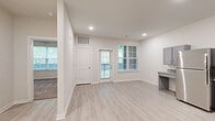 Located at 2050 Wood Duck Ct in Franklin, TN, this single-story, one-bedroom, one-bathroom residence offers a thoughtfully designed and efficiently laid-out living space. The open kitchen is a standout feature, showcasing grey shaker-style cabinetry, granite countertops, light wood-look luxury vinyl plank flooring, and a full suite of black appliances including a gas range, refrigerator, dishwasher, and microwave. Recessed lighting illuminates the kitchen, which also includes a built-in desk area, adding functional versatility. The bedroom is carpeted for comfort and features a ceiling fan with light fixture and a window with blinds that allows natural light and outdoor views of the surrounding greenery. The bathroom is designed with accessibility in mind, equipped with stainless steel grab bars near the toilet and bathtub/shower combination, and matching light wood-look flooring that ties the space together. A dedicated in-unit laundry area accommodates a full-size front-loading washer and dryer, adding everyday convenience. Throughout the home, neutral tones and clean finishes create a bright, welcoming ambiance well-suited for comfortable, modern living in the Franklin, Tennessee community.