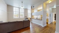 Located at 166 W Broadway St in Winona, MN, this 2-bedroom, 1-bathroom unit offers a well-designed single-floor layout with a thoughtful mix of hardwood and carpeted flooring throughout. The open-concept living and dining area is bright and inviting, anchored by large, multi-pane windows that flood the space with natural light and a ceiling fan overhead. Rich hardwood floors extend through the main living area, adding warmth and character.

The galley-style kitchen is efficiently arranged with warm wood cabinetry lining both sides, a double sink, and white appliances including a range, dishwasher, refrigerator, and microwave. A pass-through counter connects the kitchen to the living area, enhancing the open feel. The kitchen opens directly into a dedicated dining area with its own large window.

Both bedrooms feature plush carpeting, ceiling fans, and generously sized windows that bring in ample natural light. The spacious primary bedroom offers a comfortable retreat, while the second bedroom provides versatile space. Five closets throughout the unit ensure excellent storage. The bathroom includes a tub-shower combination with hardwood flooring. A hallway connects the private areas of the unit seamlessly to the shared living spaces.