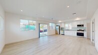 This contemporary 1810 square foot residence in Los Angeles offers a harmonious blend of style and functionality across three floors. The home boasts 4 bedrooms and 4 bathrooms, with the primary bedroom spanning a generous 200 square feet. The ground floor covers 550 square feet, while the first and second floors measure 640 and 610 square feet respectively.

The interior design is characterized by a sleek, modern aesthetic with clean lines and a neutral color palette. Light-toned hardwood flooring flows throughout, complementing the crisp white walls and creating a sense of spaciousness. Recessed lighting adds to the contemporary ambiance, while large windows and glass doors allow for ample natural light and views of the surroundings.

The kitchen is a highlight, featuring white cabinetry, stainless steel appliances, and a subtle blue backsplash. It's equipped with a gas range, built-in microwave, and a convenient in-unit washer and dryer. The bathrooms showcase a mix of modern fixtures, including frameless glass shower enclosures, illuminated mirrors, and stylish tile work.

The bedroom spaces are generously sized, with built-in closets for storage. Some rooms offer balcony access, providing outdoor space and city views. The home's layout includes a staircase connecting all three levels, ensuring easy navigation throughout the property.

This residence combines comfort and contemporary design, making it an attractive option in the Los Angeles real estate market.