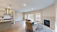 Located at 1190 Fairbourne Dr in Grand Rapids, Michigan, this well-appointed two-story home offers three bedrooms and three bathrooms across a thoughtfully designed layout. The main floor opens into a bright, airy living room highlighted by a tile-surround fireplace, large windows, and sliding glass doors that bathe the space in natural light and provide views of the surrounding landscape. Light-toned hardwood-style flooring flows throughout the main level, adding warmth and continuity. The kitchen is a standout feature, boasting gray shaker-style cabinetry, granite countertops, a classic subway tile backsplash, stainless steel appliances, a wall-mounted range hood, and a central island with pendant lighting — ideal for both everyday living and entertaining. A convenient half bath with granite vanity and wood-look flooring rounds out the main floor. Upstairs, the spacious primary bedroom offers plush carpeting, multiple windows, and generous proportions. A dedicated walk-in closet with wire shelving provides ample storage. Two additional carpeted bedrooms offer flexibility for guests or home office use. The upper-level bathrooms feature granite vanities and clean, functional finishes. A washer and dryer are also located on the upper floor for added convenience.