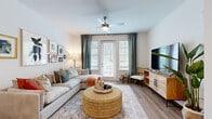 Located at 8402 IBM Drive in Charlotte, NC, this one-bedroom, one-bathroom unit offers a smartly designed single-floor layout that maximizes every square foot. The open-concept living room serves as the heart of the space, featuring light wood-style flooring, a ceiling fan, and a set of French doors that flood the room with natural light and provide outdoor access. The living area flows seamlessly into the kitchen and hallway, creating a connected, airy feel.

The kitchen is a standout feature, showcasing gray shaker-style cabinetry extending floor to ceiling, granite countertops, a white subway tile backsplash, and a full suite of stainless steel appliances. A peninsula with bar seating adds both functionality and a casual dining option.

The bedroom is carpeted for comfort and features a ceiling fan, natural light from a large window, and a distinctive arched terracotta accent wall above the bed area, adding a bold design element to the otherwise neutral palette.

The bathroom is finished with wood-look flooring, a granite-topped gray vanity, and a full tub-shower combination. The hallway connects all rooms efficiently, maintaining a clean and organized flow throughout the unit.