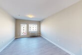 Located at 405 Lake Lida Ln in Rochelle, Illinois, this single-floor unit offers a thoughtfully laid-out floor plan with four bedrooms, a kitchen, and a hallway. Light hardwood-style flooring runs throughout the unit, contributing to a clean, modern aesthetic complemented by neutral-toned walls and crisp white trim.

The kitchen is a standout feature, designed with two-tone cabinetry — light wood uppers paired with darker lower cabinets — and light-colored countertops. It is equipped with a white electric range, microwave, refrigerator, and a stainless steel sink, all arranged in an efficient L-shaped layout that opens into the main living area.

Each of the four bedrooms is finished with the same light flooring and warm neutral walls, creating a consistent and calm atmosphere throughout. The bedrooms are naturally lit by windows that allow outside views, and each room includes an individual wall-mounted PTAC heating and cooling unit for independent climate control. The primary bedroom offers a comfortable and functional footprint. Additional bedrooms, while more compact, are efficiently designed with closet access.

A connecting hallway ties the rooms together seamlessly. The overall design of the unit is clean, functional, and move-in ready, making it well-suited for shared or multi-occupant living.