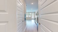 Located at 1450 Peachtree Industrial Blvd in Sugar Hill, GA, this single-floor unit offers a thoughtfully designed layout that maximizes its efficient footprint. Light hardwood flooring flows throughout the space, complementing the clean white walls and recessed lighting that keep the interior bright and airy.

The kitchen is a standout feature, outfitted with crisp white shaker-style cabinetry, granite-look countertops, and a full suite of stainless steel appliances including a refrigerator with ice and water dispenser, electric range, over-the-range microwave, and dishwasher. A dual-basin sink adds functionality, while the open layout allows the kitchen to connect seamlessly with the main living area.

The living area is bathed in natural light from large windows and a glass door that opens to a private balcony, offering outdoor views and ventilation. Two modern ceiling fans with integrated lighting fixtures provide comfort and a contemporary aesthetic touch to the space.

The bathroom is finished with a white vanity topped with a granite-look surface, a walk-in shower with subway tile surround, and wood-look flooring that ties into the rest of the unit. A mirrored vanity adds depth to the room. A closet with louvered bifold doors provides dedicated storage within the unit. Overall, the space presents a modern, move-in-ready interior with clean design choices throughout.