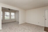 Located at 4150 Arkwright Rd in Macon, Georgia, this single-floor residence offers a practical and comfortable layout across a well-organized floor plan. The living and dining areas are finished with neutral-toned carpet and cream-colored walls, creating a clean, versatile backdrop. An open passageway connects the main living space to a bright front room with multiple windows, allowing natural light to flow throughout.

The kitchen is equipped with light wood cabinetry, a peninsula countertop that opens to the adjacent living area, white appliances including an electric range and refrigerator, a dishwasher, and a double sink — all set on durable wood-look flooring. A range hood and ample upper and lower cabinet storage add functional efficiency to the space.

The bedrooms are carpeted and generously sized, each featuring ceiling fans and windows with blinds that offer views of surrounding greenery. The textured ceilings throughout the home add a classic finish consistent with the overall design.

The bathrooms are outfitted with wood-look plank flooring, a tub-shower combination, toilet, and a single-sink vanity topped with a marble-patterned countertop and framed by a wall mirror. The entry foyer transitions smoothly from wood-look flooring to carpet, anchoring the home's cohesive interior design.