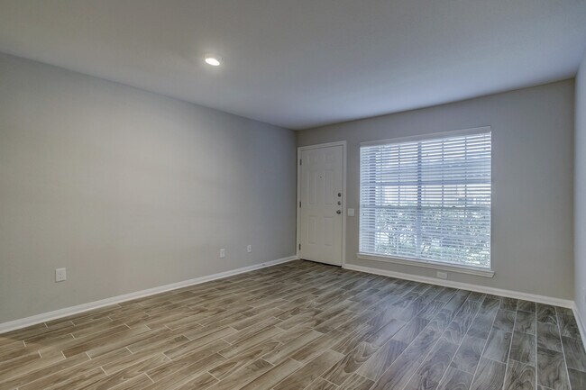 Amplia sala de estar con vistas al exterior, sin muebles. - 1880 White Oak Dr. Apt 119