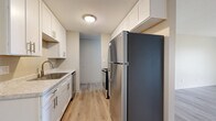 Located at 20452 Iberia Ave in Lakeville, MN, this one-bedroom, one-bathroom unit offers a thoughtfully organized single-floor layout. The galley-style kitchen is a standout feature, showcasing white shaker cabinetry extending to the ceiling, light stone countertops, a stainless steel refrigerator, range, and dishwasher, along with a built-in sink — all set atop light hardwood-style flooring that extends throughout the main living areas. A ceiling fan overhead connects the kitchen to the open dining area, creating a cohesive and functional flow. The living room is generously sized, featuring the same light flooring, a ceiling fan, and a large sliding glass door that invites natural light and provides outdoor views. The bedroom offers comfortable carpeting, a natural light-filled window with outdoor views, a dedicated closet, and direct access to the bathroom. The full bathroom is clean and functional, featuring white tile flooring, a tub/shower combination with grab bars, a white vanity with storage, and a bright, neutral palette. Two closets provide practical storage throughout. A hallway connects all spaces efficiently, completing this well-planned and move-in-ready home.