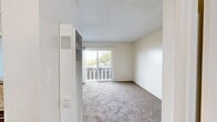 Located at 2490 Lancaster Dr in Richmond, CA, this one-bedroom, one-bathroom unit offers a well-organized layout across a single floor. The combined kitchen and living room serves as the heart of the home, where the kitchen impresses with granite countertops, dark cabinetry, a stainless steel sink, and a built-in dishwasher. The living area is carpeted and features a sliding glass door that opens to a private balcony, offering pleasant outdoor views of the surrounding neighborhood and distant scenery beyond. A wall-mounted heating and cooling unit ensures year-round comfort. The bedroom is a comfortable, carpeted retreat with a window framing lush tree views, a closet with a hanging rod, and access to an additional walk-in closet for ample storage. The bathroom features wood-look vinyl flooring, a granite-topped vanity with dark cabinetry, and a full shower-tub combination. Textured ceilings and neutral walls are consistent throughout, lending the space a clean, cohesive aesthetic. This unit provides a functional and practical living environment with convenient access to outdoor space.