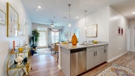 Located at 1001 Marshall Ave in Cincinnati, OH, this well-appointed 5-bedroom, 5-bathroom residence offers a thoughtfully designed single-floor layout. The open-concept kitchen and living area serve as the heart of the home, featuring a granite-topped island with a stainless steel dishwasher, gray cabinetry with modern hardware, and pendant lighting. Wood-style flooring flows throughout the common areas, connecting seamlessly into the living room, which is brightened by large windows and a glass door opening to an outdoor area. A ceiling fan adds comfort to the welcoming living space. Each of the five bedrooms is carpeted and sized to accommodate a full bed, desk workspace, and personal storage, with dedicated closets providing ample organization. The primary bedroom is generously proportioned with multiple windows that invite natural light. Every bedroom is paired with its own private bathroom, each finished with granite vanities, gray cabinetry, and tub/shower combinations with tile surrounds. Two hallways connect the rooms efficiently throughout the unit. The consistent, contemporary aesthetic—marked by neutral tones, clean lines, and quality finishes—creates a cohesive and functional living environment suited for shared or individual occupancy.
