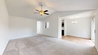 Located at 7 Deer Haven Ct in Florence, Kentucky, this two-story home offers four bedrooms, two full bathrooms, and a well-organized layout spread across two floors. The main level houses the combined kitchen and living room, where a galley-style kitchen stands out with dark gray cabinetry, white countertops, wood-look flooring, and black appliances. Natural light pours in through multiple windows, and a sliding glass door leads to an outdoor area. The open living room features vaulted ceilings and a ceiling fan, creating an airy, comfortable atmosphere. An attached garage with an automatic opener provides convenient access and additional storage. The upper level contains all four bedrooms, each carpeted and equipped with ceiling fans. The generously sized primary bedroom features vaulted ceilings, multiple windows, and a walk-in closet with wire shelving. The additional bedrooms are well-proportioned with ample natural light. Two full bathrooms serve the home, one of which includes a tub/shower combo and hardwood-style flooring. A staircase connects the two floors, and a hallway provides easy access to all upper-level rooms. The home's clean, neutral palette and practical layout make it a functional and comfortable residence.