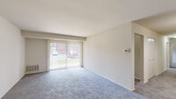 Located at 11 Cobblestone Ct in Pikesville, Maryland, this single-floor residence offers a practical and comfortable layout designed for everyday living. The spacious living area is a standout feature, finished with plush wall-to-wall carpeting and anchored by a large sliding glass door fitted with vertical blinds. This generous opening floods the room with natural light and provides direct outdoor views, creating an airy and welcoming atmosphere. A wall-mounted thermostat adds convenient climate control to the space.

The bedrooms are carpeted and well-proportioned, each featuring windows with horizontal blinds that allow for adjustable natural light. The rooms offer a clean, neutral palette with ample wall space, making them versatile for various furniture arrangements.

The kitchen is outfitted with rich, warm-toned wooden cabinetry extending to the upper walls, complemented by granite-look countertops, a stainless steel sink, and black appliances including a gas range and an over-the-range microwave. The tile flooring adds durability to this functional cooking space.

Two bathrooms serve the residence. One features a wood-vanity with a white countertop, a mirrored medicine cabinet, a subway tile wainscot, and wood-look vinyl flooring. The second bathroom includes a stand-up shower with a frosted glass door, a wall-mounted sink, and matching tile wainscoting and flooring, maintaining a cohesive, clean aesthetic throughout.