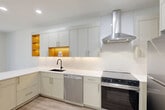 Located at 1801 N Beauregard St in Alexandria, VA, this one-bedroom, one-bathroom residence offers a thoughtfully designed single-floor layout with a clean, modern aesthetic throughout. Light-toned luxury vinyl plank flooring runs seamlessly across the living areas, complementing the bright white walls and recessed lighting that keep the space feeling open and airy.

The kitchen is a standout feature, boasting sleek sage-toned flat-front cabinetry, crisp white quartz countertops, a subway tile backsplash, and a full suite of stainless steel appliances including a dishwasher, range with a wall-mounted vent hood, and a full-size refrigerator. Warm amber-lit open shelving adds a stylish accent within the cabinetry.

The combined dining and living area is bathed in natural light from large floor-to-ceiling windows that frame lush, wooded views—a serene backdrop that extends to the private balcony, where mature trees and green landscaping create a peaceful outdoor retreat.

The generously sized primary bedroom continues the bright, minimal design with large windows overlooking the treetops. The bathroom features a walk-in shower with white subway tile walls, a built-in niche, and mosaic tile flooring. Additional conveniences include two closets, a dedicated laundry area, and a hallway connecting all spaces efficiently.