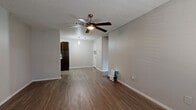 Located in Georgetown, TX, this single-story, one-bedroom, one-bathroom unit offers a well-organized layout designed to maximize every square foot of its compact footprint. Throughout the home, warm wood-look flooring provides a cohesive and easy-to-maintain surface that flows seamlessly from room to room.

The combined living and dining area serves as the heart of the home, featuring neutral gray walls, a textured ceiling, and a ceiling fan with an integrated light fixture for year-round comfort. Natural light enters through windows fitted with horizontal blinds, and a front entry door opens directly into this welcoming open space.

The galley-style kitchen is thoughtfully appointed with rich, dark espresso cabinetry, white countertops, a subway tile backsplash, and black appliances including a range, over-the-range microwave, and refrigerator. A double sink and dishwasher round out the functional workspace.

The bedroom is a comfortable retreat, enhanced by a ceiling fan, a window for natural light, and direct access to a walk-in closet with built-in shelving. Three additional closets throughout the unit provide exceptional storage capacity.

The bathroom features a dark-toned vanity with a vessel sink, a framed mirror, and a shower-tub combo, all finished with the same wood-look flooring found throughout the home.