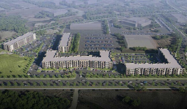 Vista aérea de Sageland Flats en Brooks, con varios edificios residenciales, zonas de aparcamiento, calles ajardinadas y entornos verdes. - Sageland Flats at Brooks