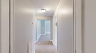 Located at 8215 Loch Raven Blvd in Towson, MD, this single-floor unit offers a practical and comfortable layout across two bedrooms, one bathroom, a kitchen, and a connecting hallway. The living area is finished with neutral-toned carpet and light grey walls, creating a clean and versatile backdrop. Multiple windows allow natural light to flow throughout, with views of the surrounding greenery providing a pleasant outdoor connection. A dedicated entry door with glass panels adds an inviting touch to the living space.

The spacious primary bedroom benefits from dual windows on adjacent walls, filling the room with ample daylight and offering generous floor space. The second bedroom similarly features carpeted floors and access to hallway connections, including what appear to be closet doors, providing useful storage. The hallway links all rooms efficiently, maintaining a logical flow throughout the unit.

The kitchen is equipped with warm wood-toned cabinetry, a gas range, and tile flooring, complemented by a window overlooking outdoor greenery. The bathroom stands out with its classic black-and-white checkered tile flooring, white subway-tiled walls, a granite-topped vanity, and a window that brings in natural light — combining vintage character with practical fixtures throughout.